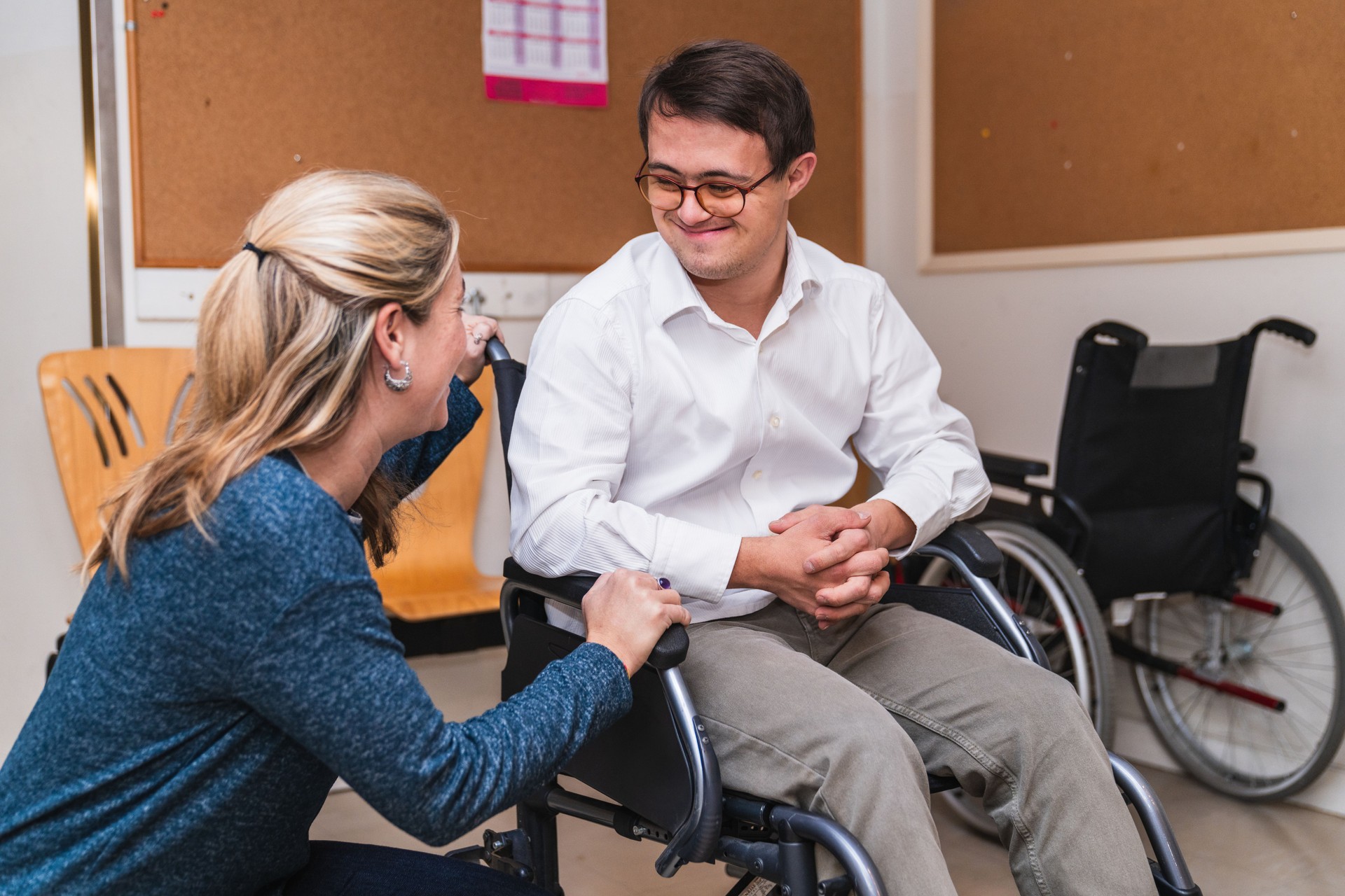 Empathetic Encounter: Woman Connects with Man in Wheelchair with Down Syndrome